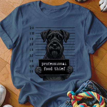 Black schnauzer with a mugshot sign reading "professional food thief".