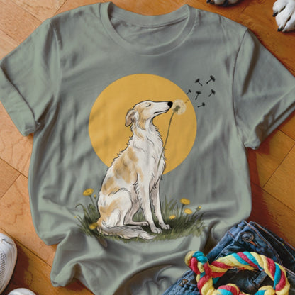 Sage green t-shirt featuring an illustration of a long-snouted dog blowing a dandelion against a yellow circle.