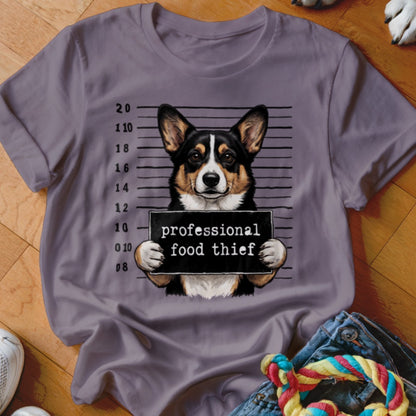T-shirt graphic of a corgi with a mugshot sign reading "professional food thief".