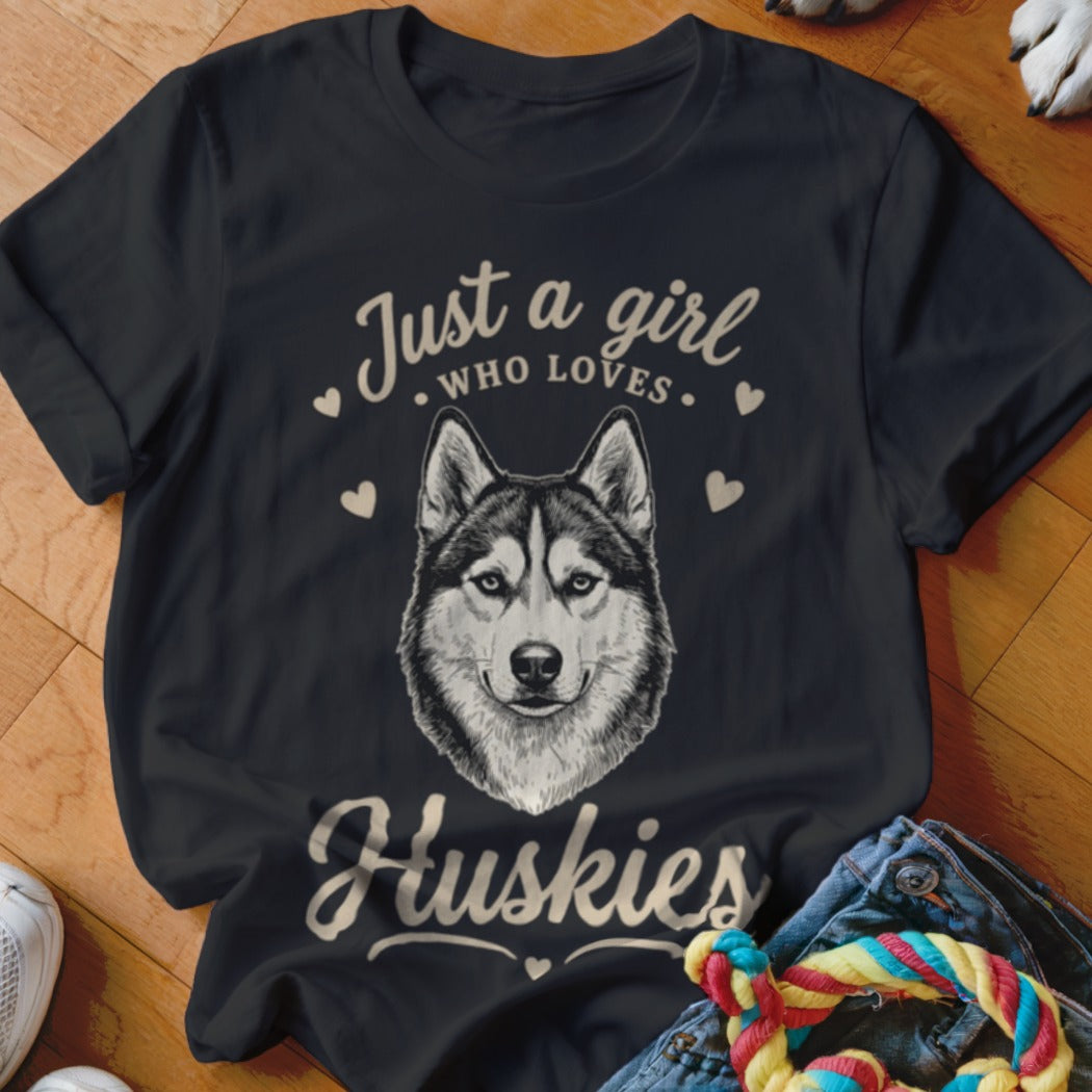 A black t-shirt printed with a husky face and the text "Just a girl who loves Huskies."