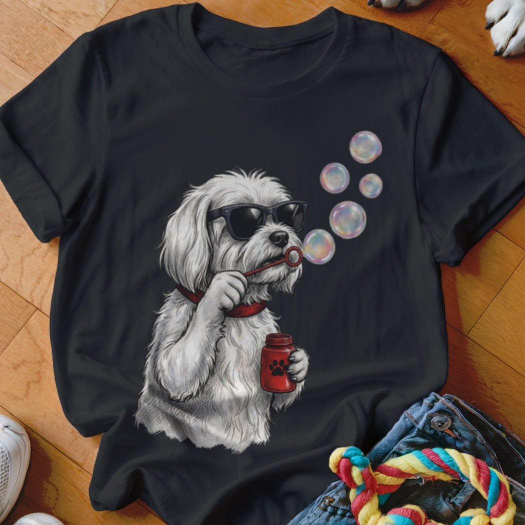 A black t-shirt printed with a graphic of a white dog wearing sunglasses and blowing bubbles.