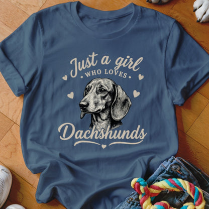 A navy blue t-shirt featuring a sketch of a dachshund surrounded by hearts and text reading "Just a girl who loves Dachshunds."