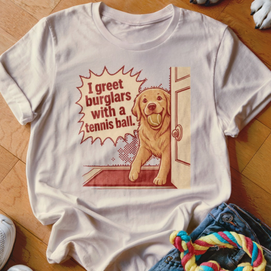 T-shirt graphic: Golden retriever with tennis ball, text "I greet burglars with a tennis ball."
