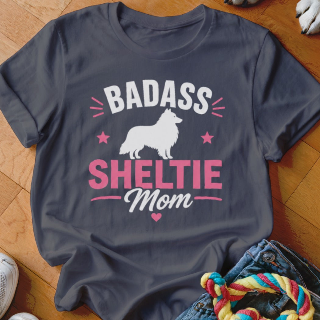 Dark t-shirt with "Badass Sheltie Mom" text and white Sheltie silhouette.