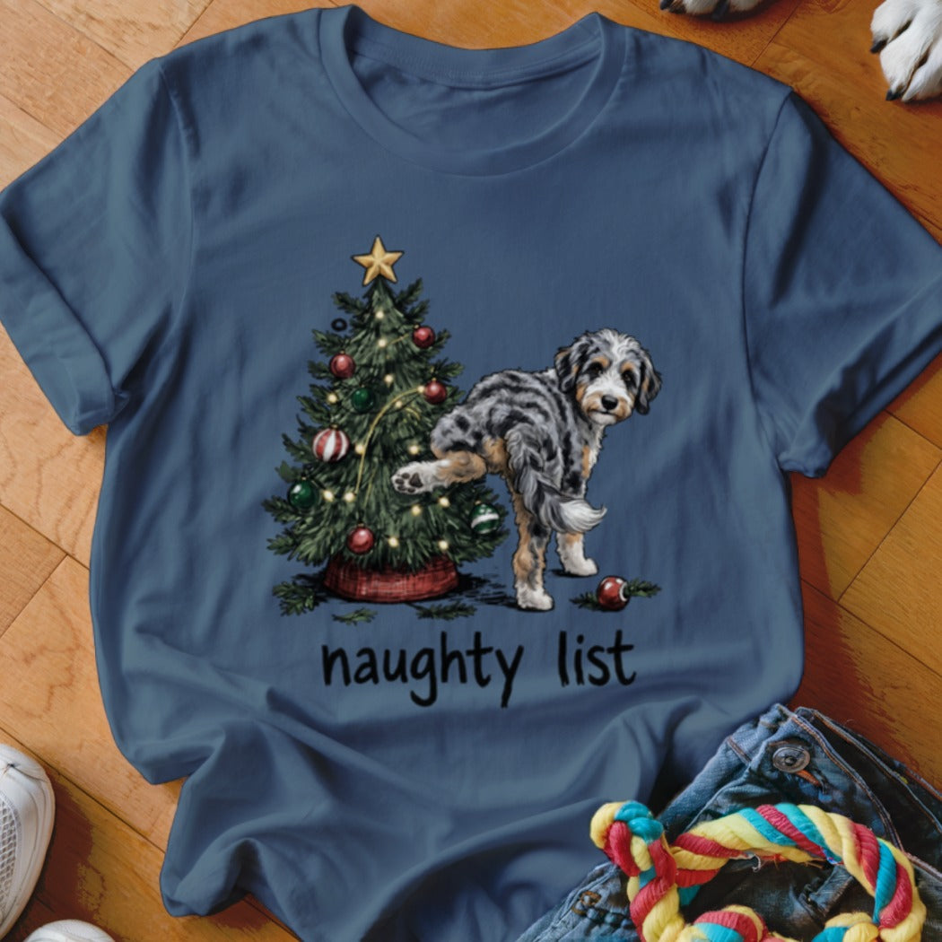 T-shirt graphic of a dog lifting its leg on a Christmas tree with the text "naughty list".