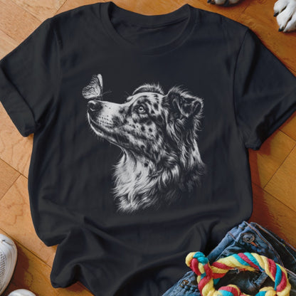 A black t-shirt features a white sketch of an Australian Shepherd looking at a butterfly on its nose.
