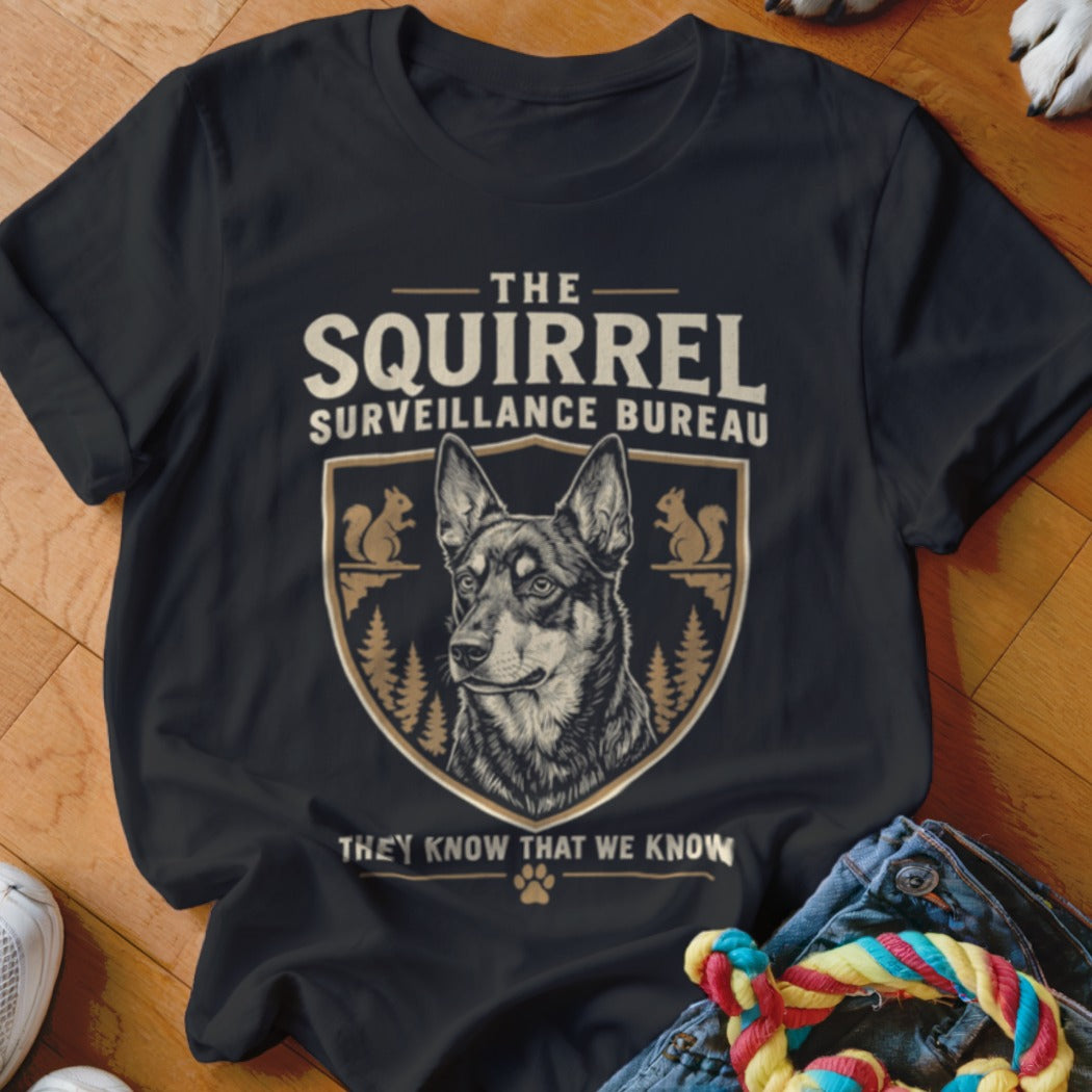 Black t-shirt featuring a graphic of a dog inside a crest with squirrel illustrations and text that reads The Squirrel Surveillance Bureau.