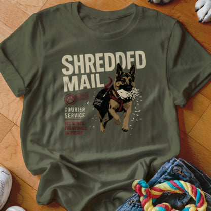 German Shepherd wearing a courier bag shreds mail on a olive green t-shirt.