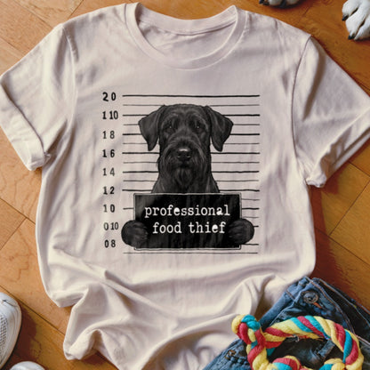 Black dog in mugshot pose holding a sign that reads "professional food thief".