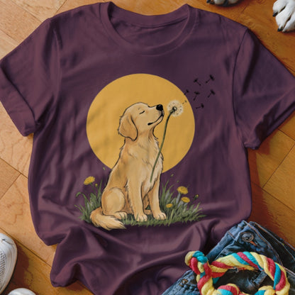 A maroon t-shirt featuring a graphic of a golden retriever blowing dandelion seeds.