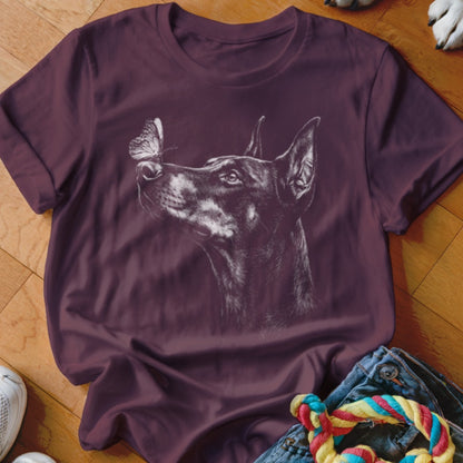 A plum crewneck t-shirt featuring a white sketch graphic of a Doberman looking at a butterfly.