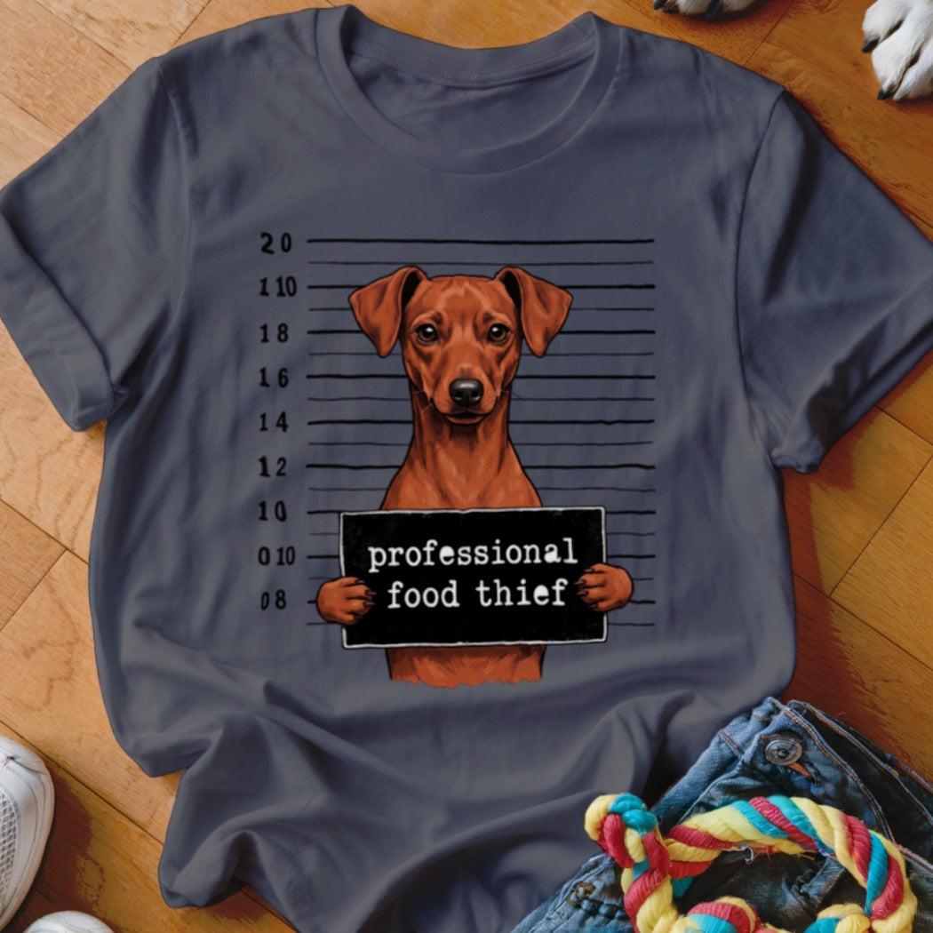 Dog in mugshot holding sign that reads "professional food thief".