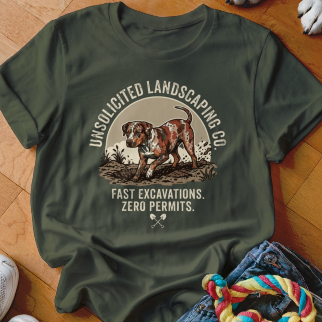 Green t-shirt with a dog digging and text "UNSOLICITED LANDSCAPING CO. FAST EXCAVATIONS. ZERO PERMITS."