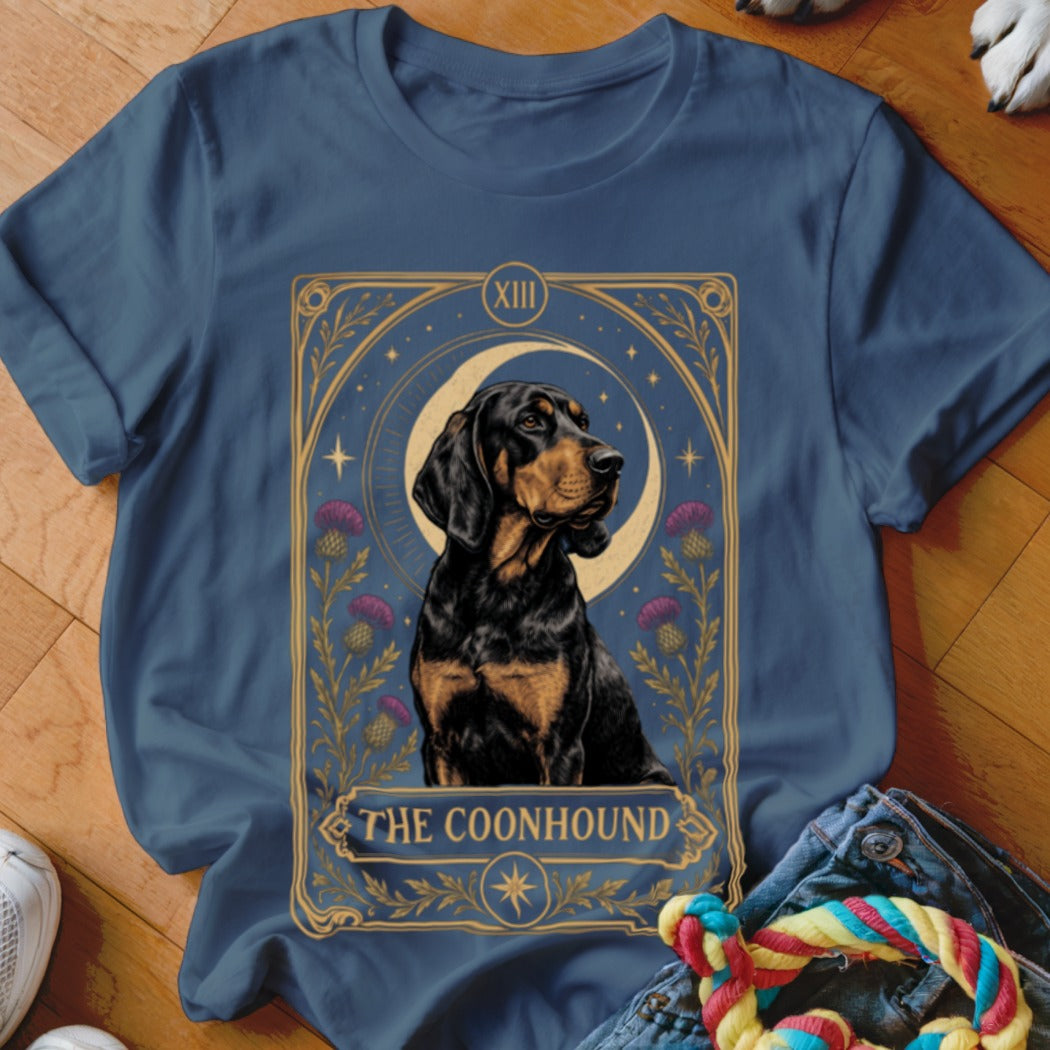 A blue t-shirt featuring a tarot card style illustration of a Black and Tan Coonhound.
