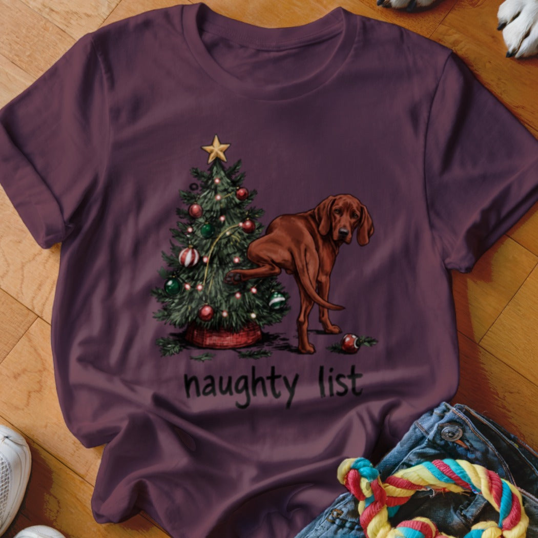 Brown dog lifting leg on Christmas tree with "naughty list" text below.