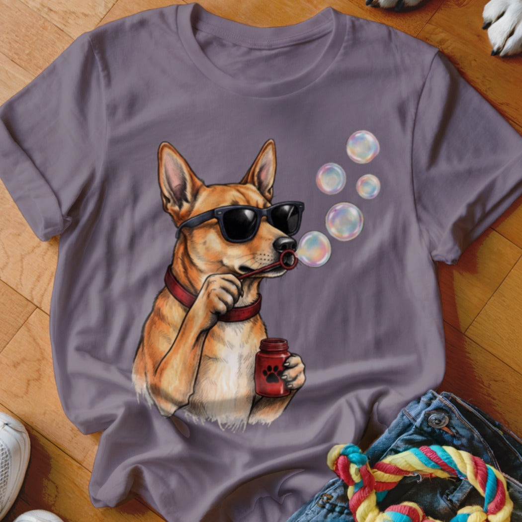 A mauve crewneck t-shirt featuring an illustration of a tan dog wearing sunglasses and blowing bubbles.