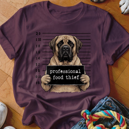 Mastiff dog mugshot with "professional food thief" sign on a t-shirt.