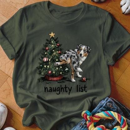 Australian Shepherd next to a Christmas tree with "naughty list" text.