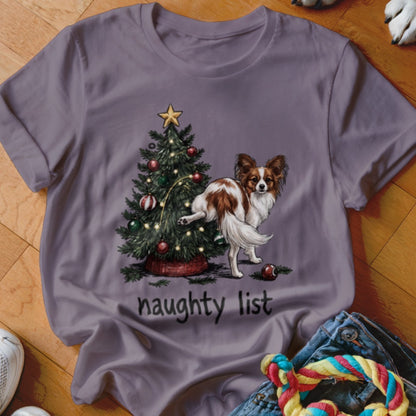 Papillon dog peeing on Christmas tree with "naughty list" text.