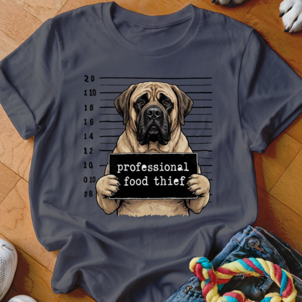 Mastiff dog mugshot with "professional food thief" sign on a t-shirt.