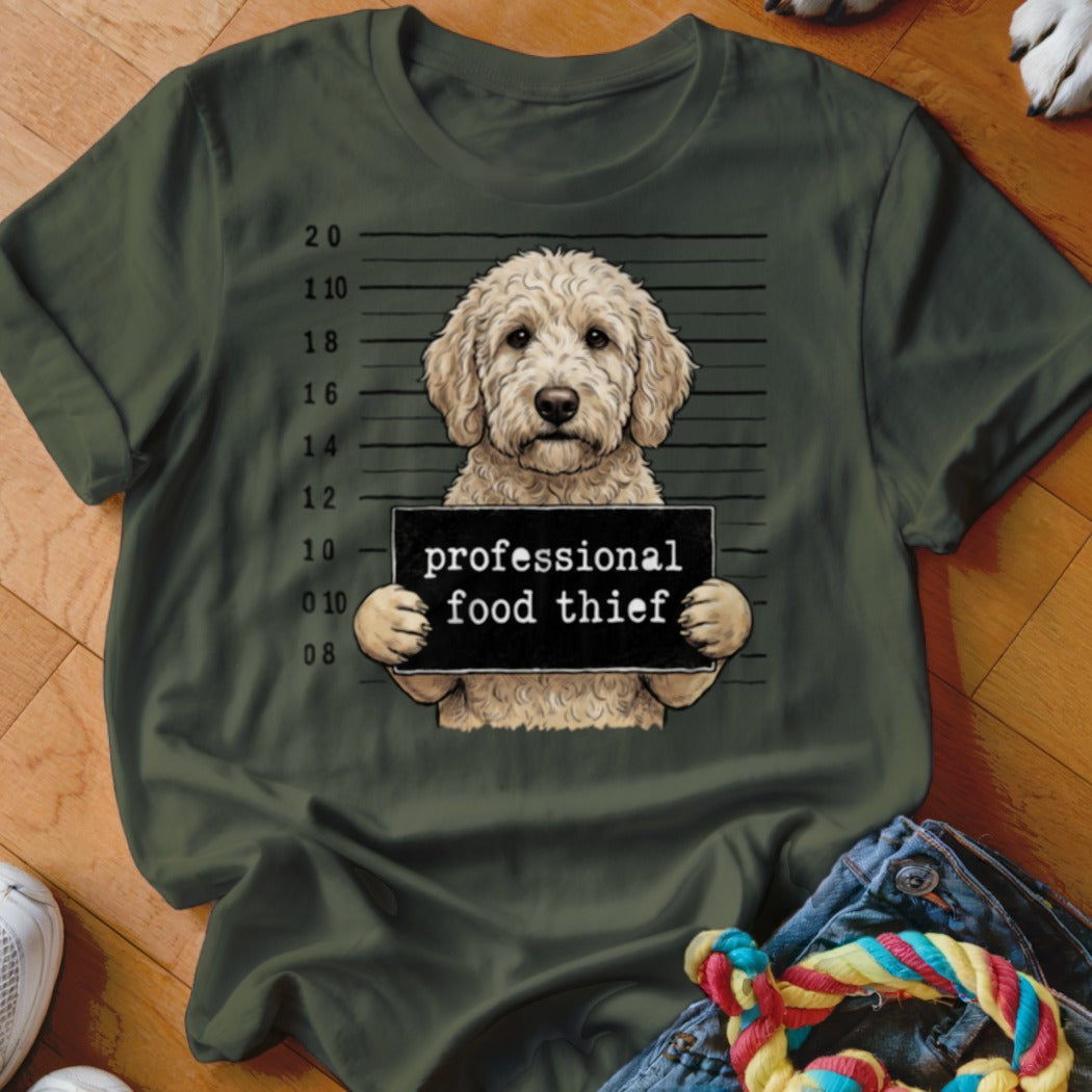 Goldendoodle holding a "professional food thief" sign in a mugshot style.