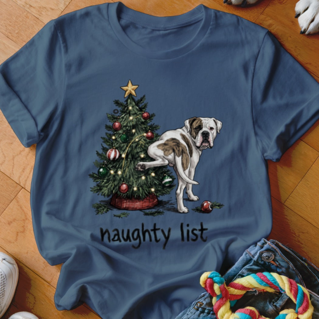 White and brown dog pees on Christmas tree with text "naughty list".