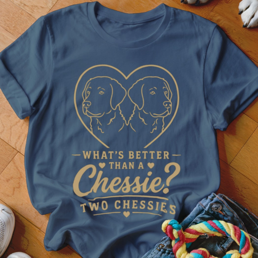 Dark blue t-shirt featuring a gold graphic of two dogs inside a heart and text reading What is better than a Chessie? Two Chessies.