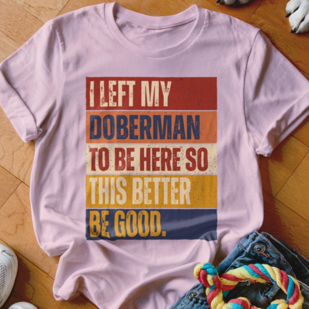 Pink t-shirt with text "I left my Doberman to be here so this better be good."