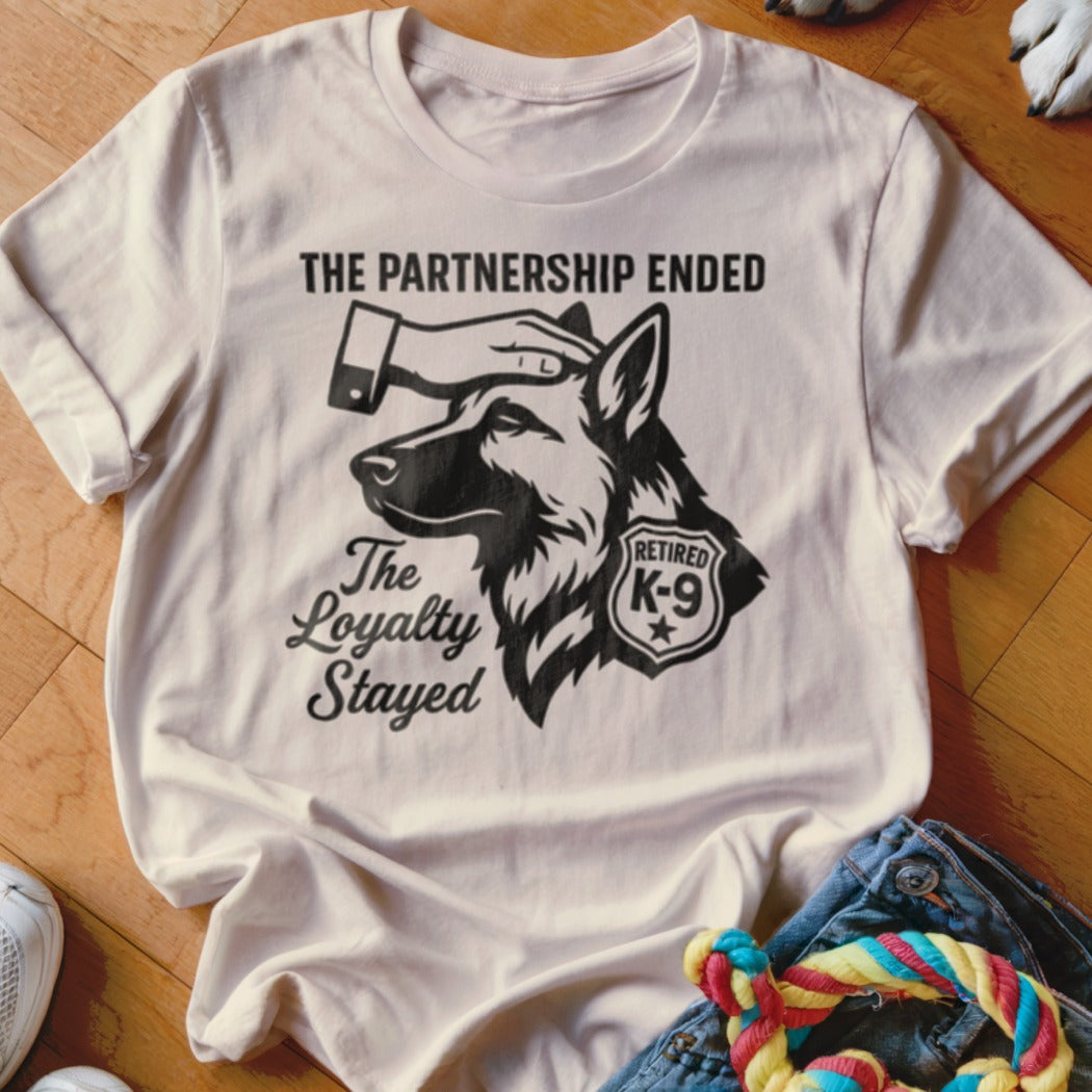 White t-shirt with graphic of German Shepherd, hand on head, and "The Partnership Ended, The Loyalty Stayed" text.