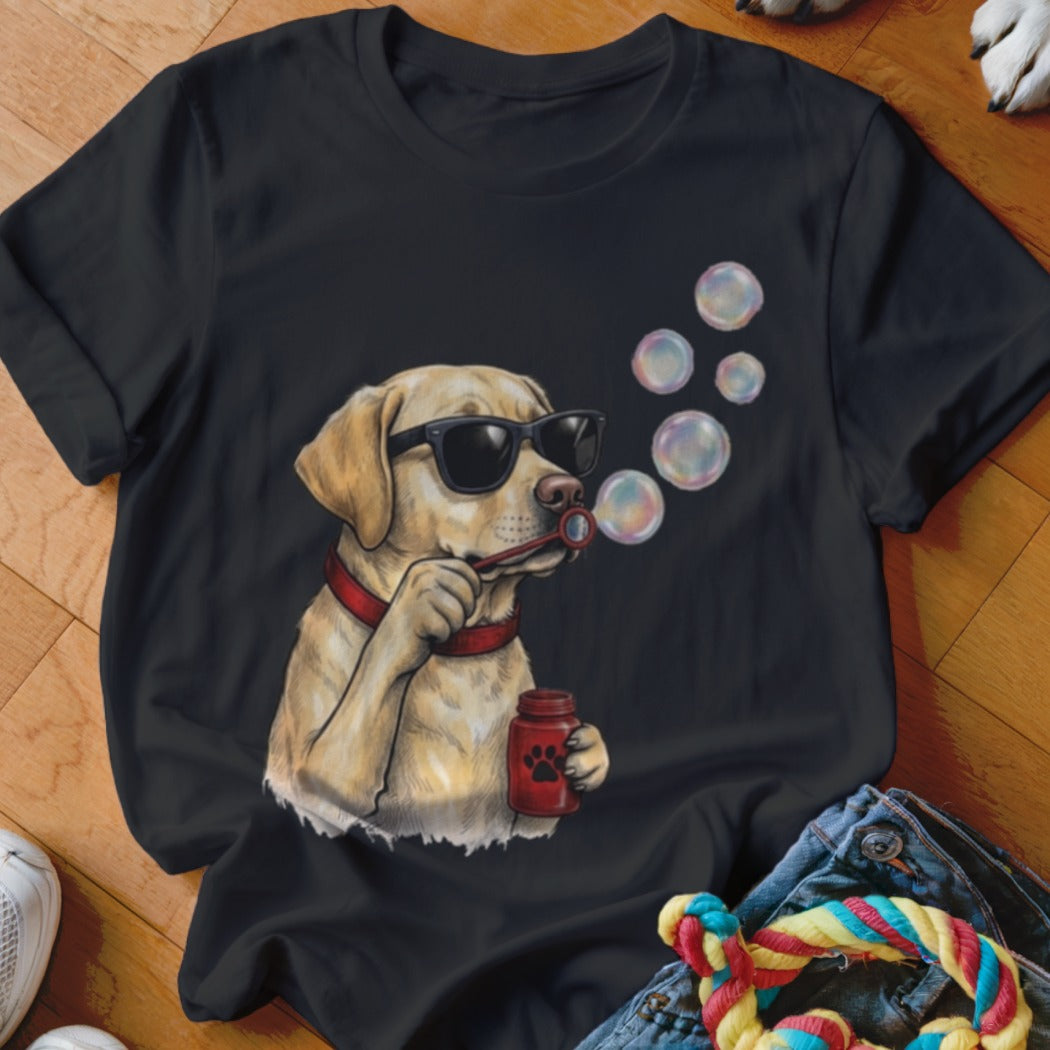 A black t-shirt featuring a graphic of a yellow lab wearing sunglasses and blowing soap bubbles.