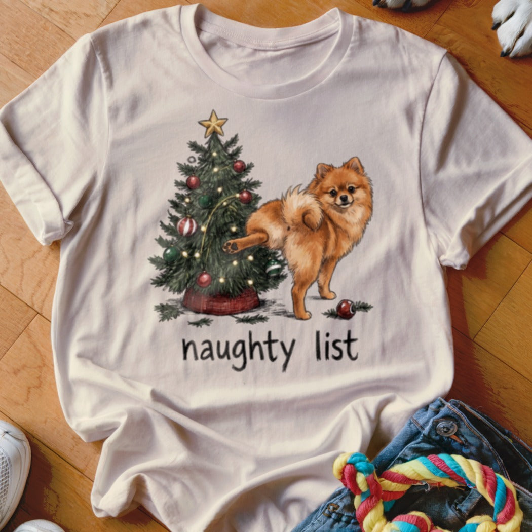 Pomeranian dog lifting leg on Christmas tree, text "naughty list"