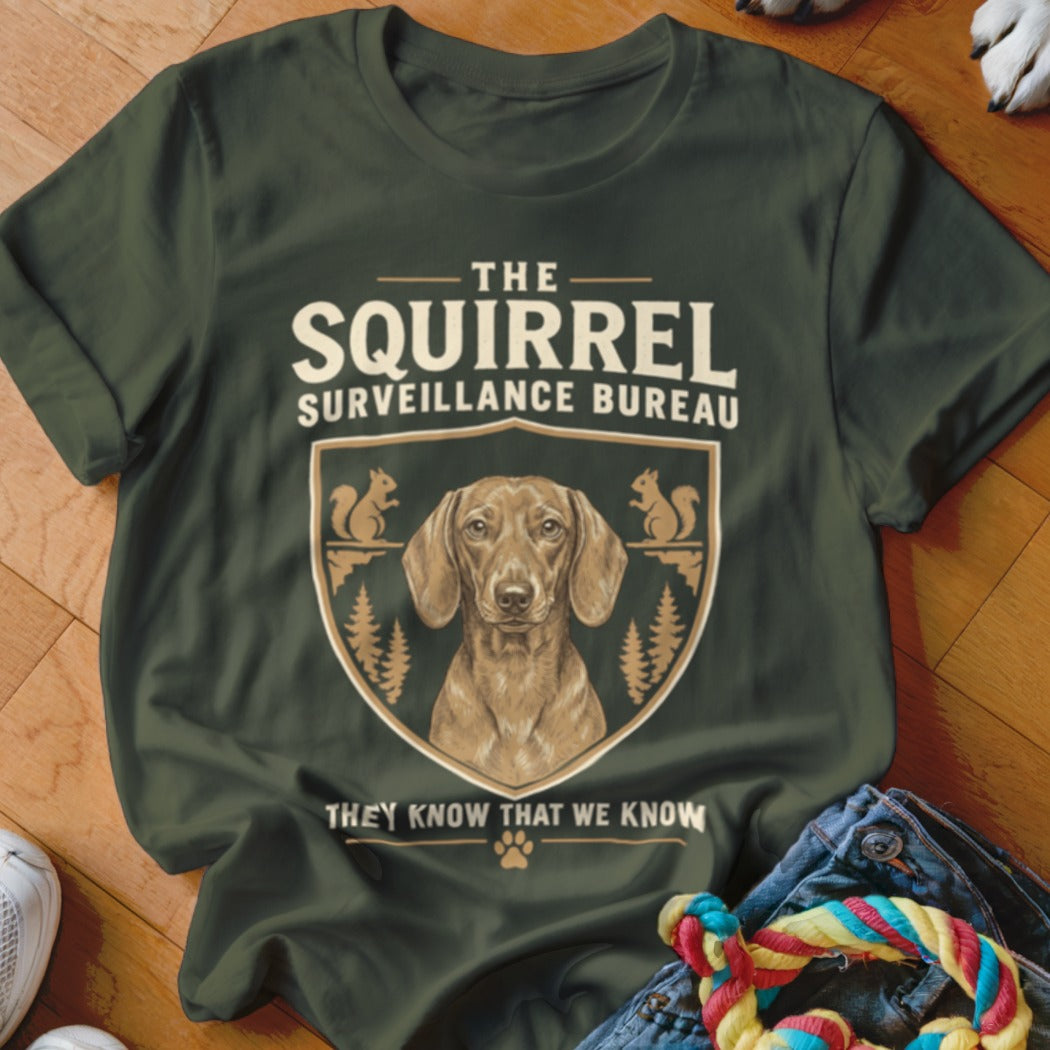Dark green t-shirt featuring a dachshund graphic with text reading The Squirrel Surveillance Bureau.