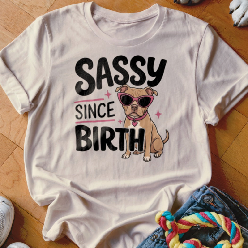 Light beige t-shirt with a pit bull wearing sunglasses and the text "SASSY SINCE BIRTH".