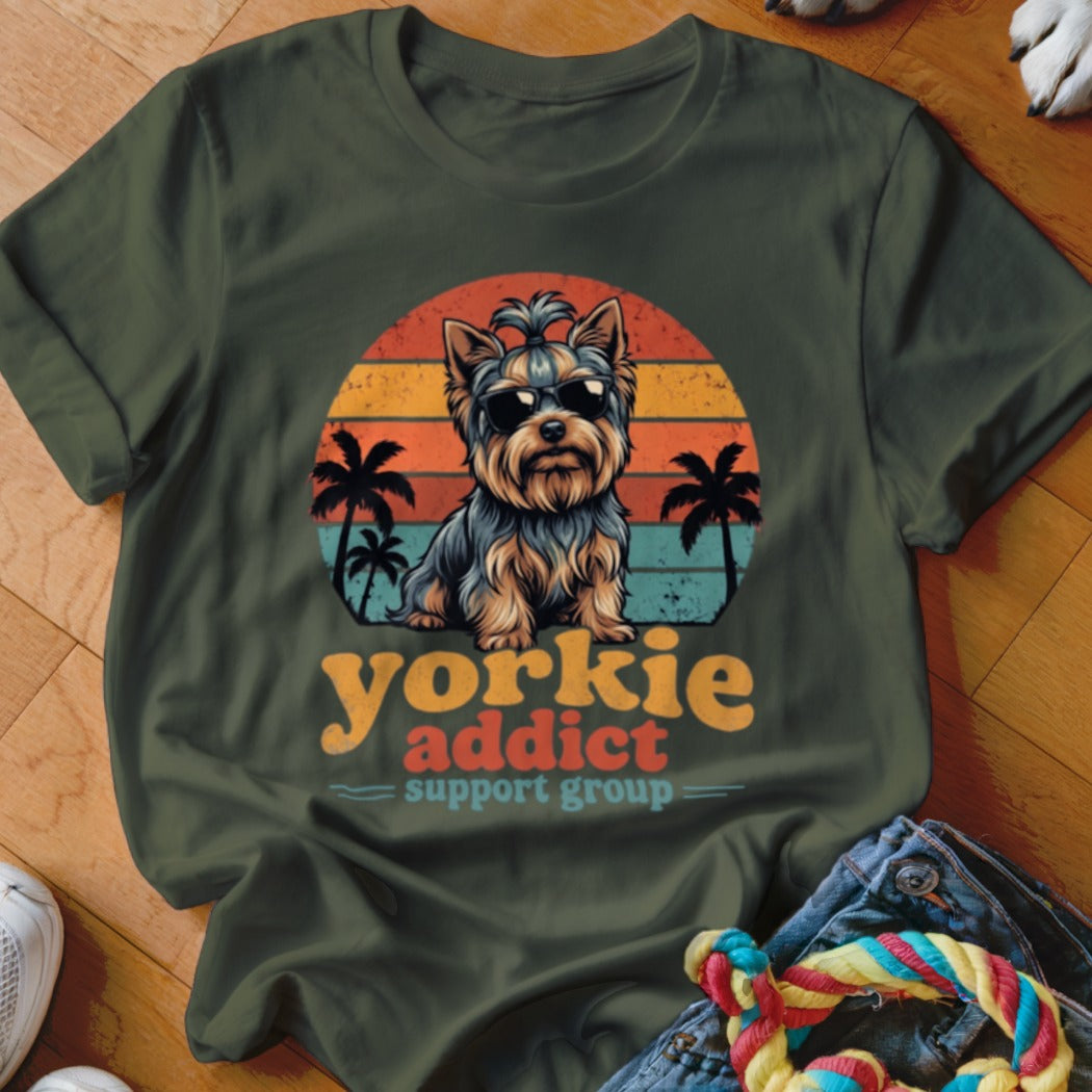 Dark green t-shirt featuring a Yorkie wearing sunglasses against a sunset graphic and palm trees with text.