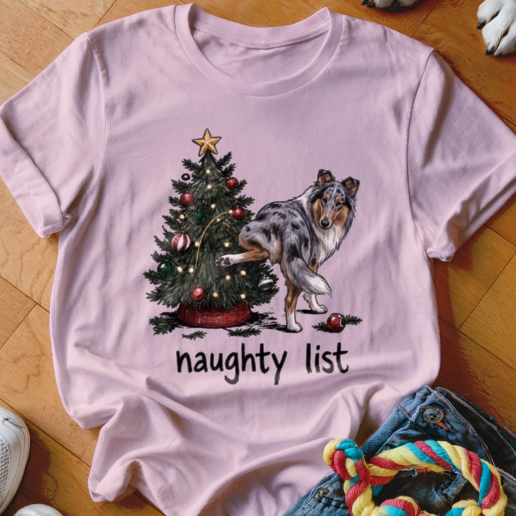Pink t-shirt with a dog kicking a Christmas tree and the text "naughty list".