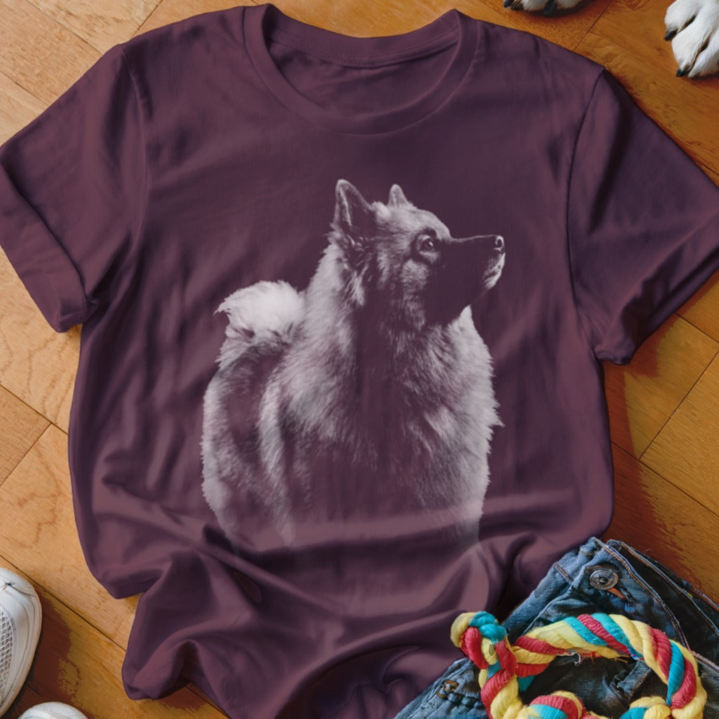 Keeshond dog portrait graphic on a dark red t-shirt.