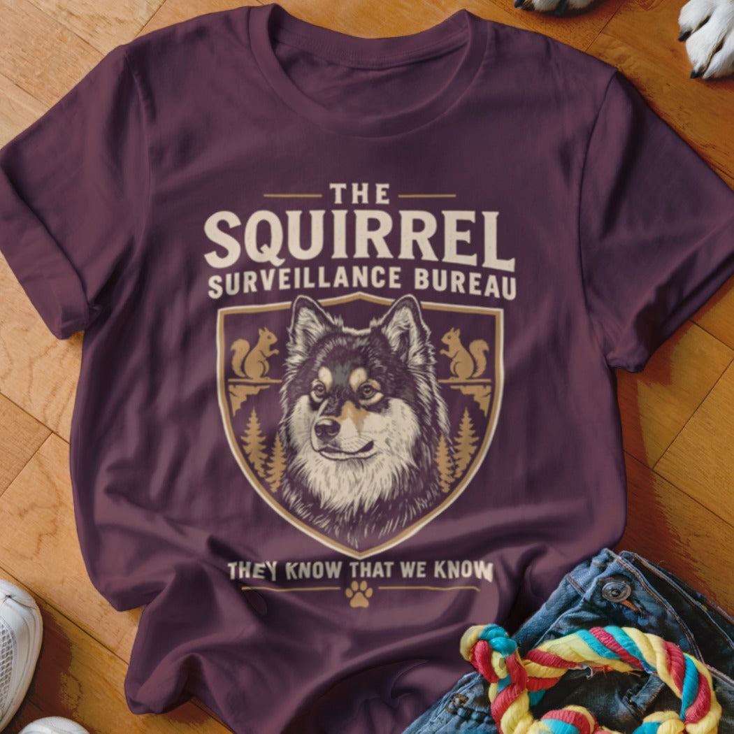 Maroon t-shirt featuring a dog graphic, crest, and text reading The Squirrel Surveillance Bureau.
