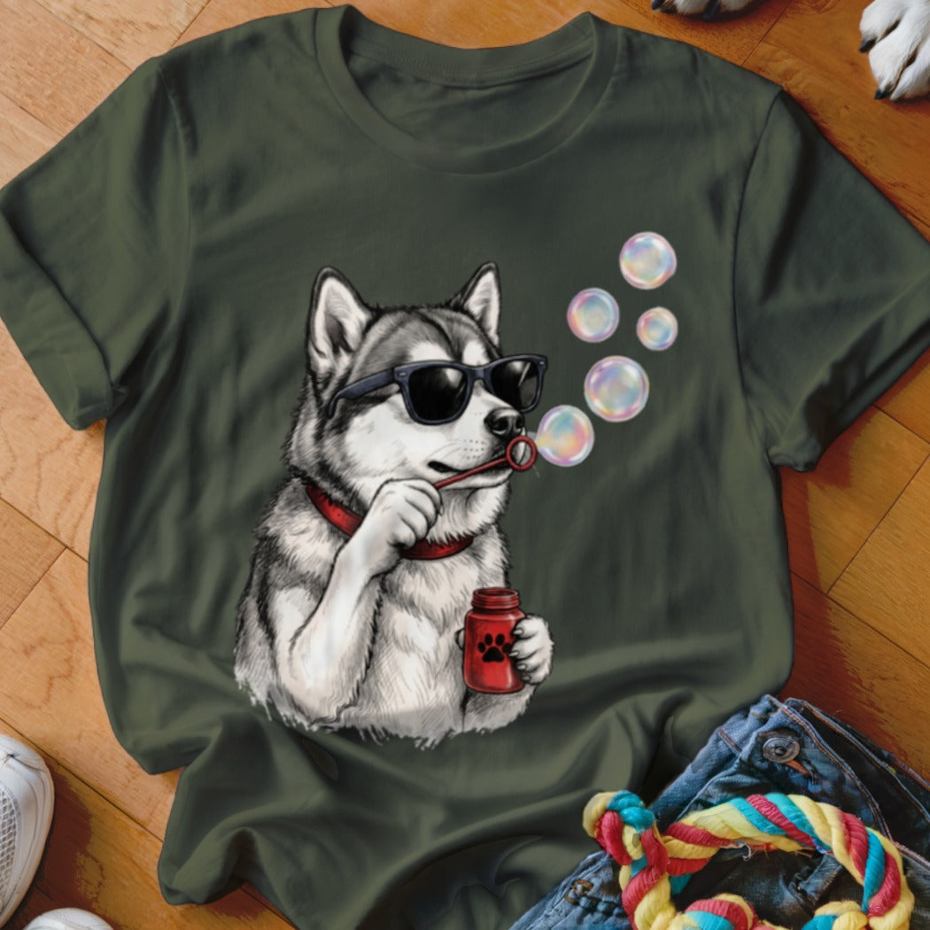 An olive green t-shirt features a graphic of a husky wearing sunglasses and blowing bubbles.