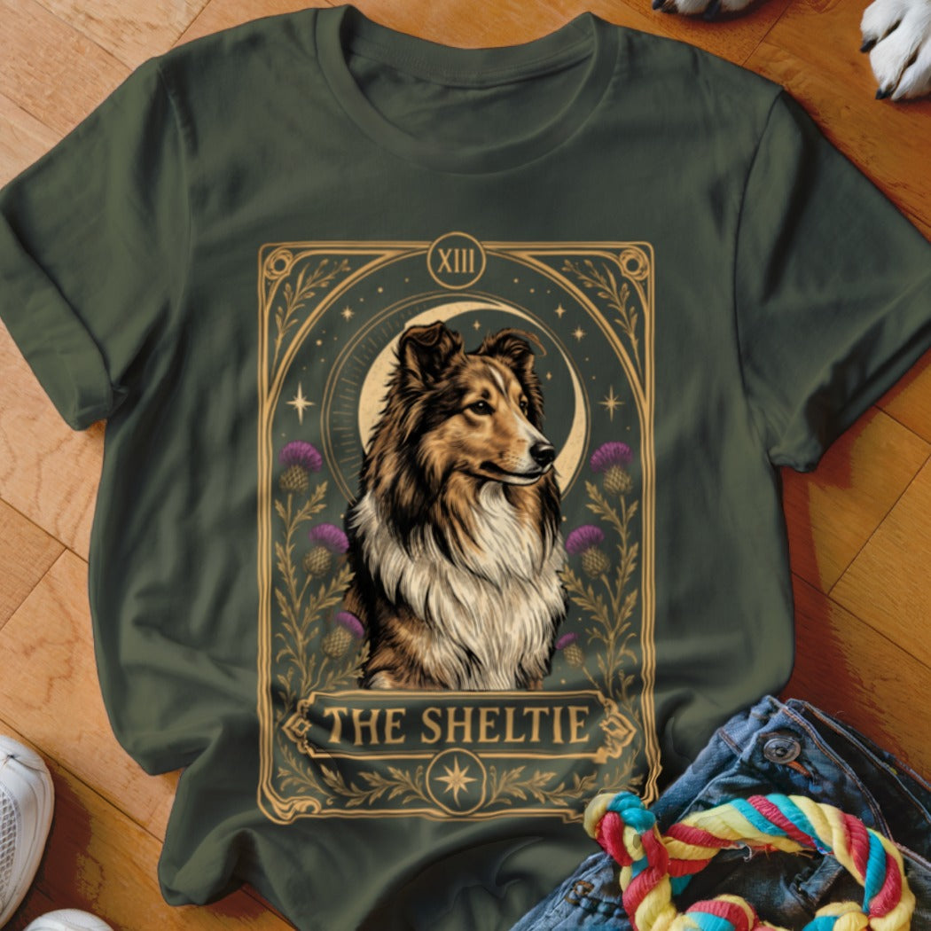Dark green t-shirt featuring a tarot card graphic of a Sheltie dog and purple thistles.
