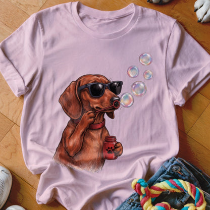 Light pink t-shirt featuring a graphic of a dachshund wearing sunglasses and blowing bubbles.