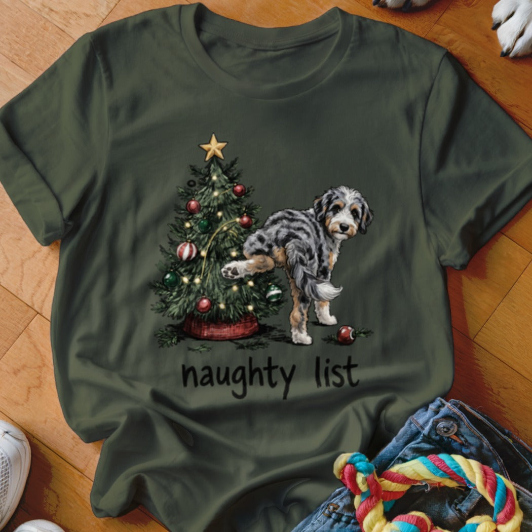 Dog lifting leg on Christmas tree with "naughty list" text.