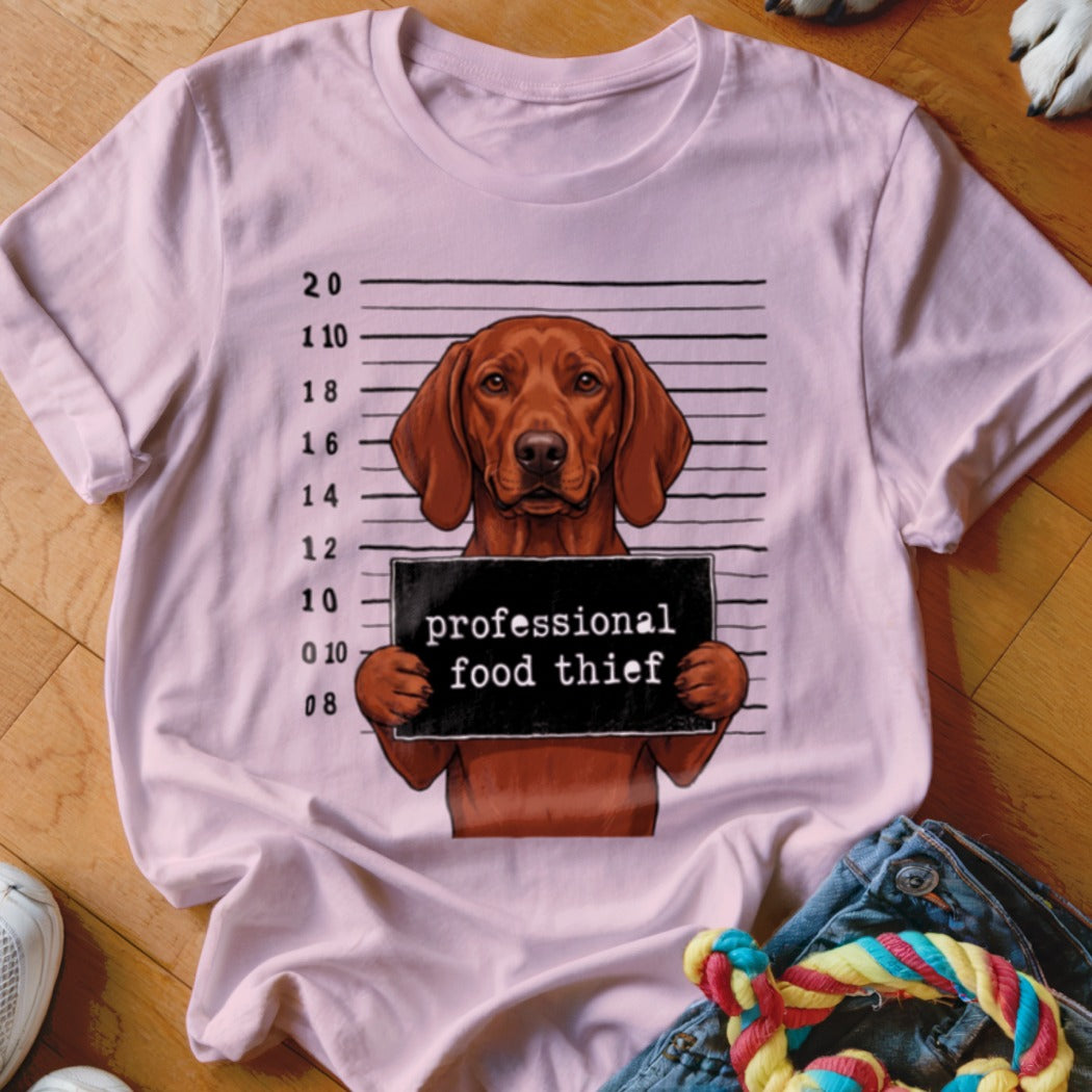 Pink t-shirt with a cartoon dog holding a "professional food thief" sign.