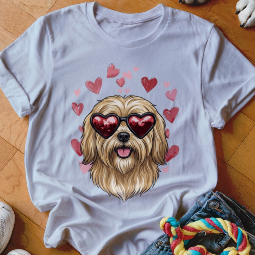 A white t-shirt featuring an illustration of a fluffy blonde dog wearing heart-shaped sunglasses, surrounded by pink hearts.