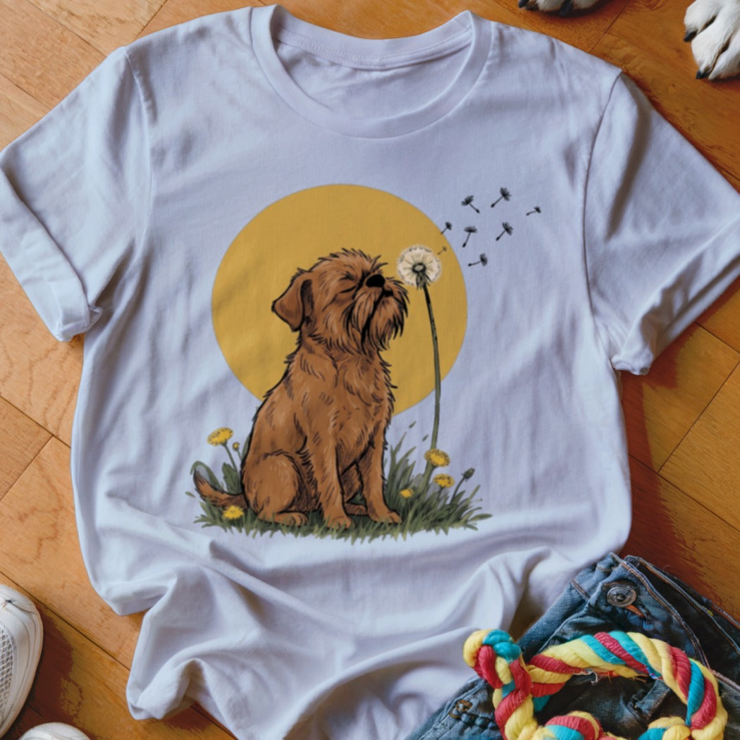 A white t-shirt featuring a graphic of a brown dog sitting among dandelions before a yellow sun.