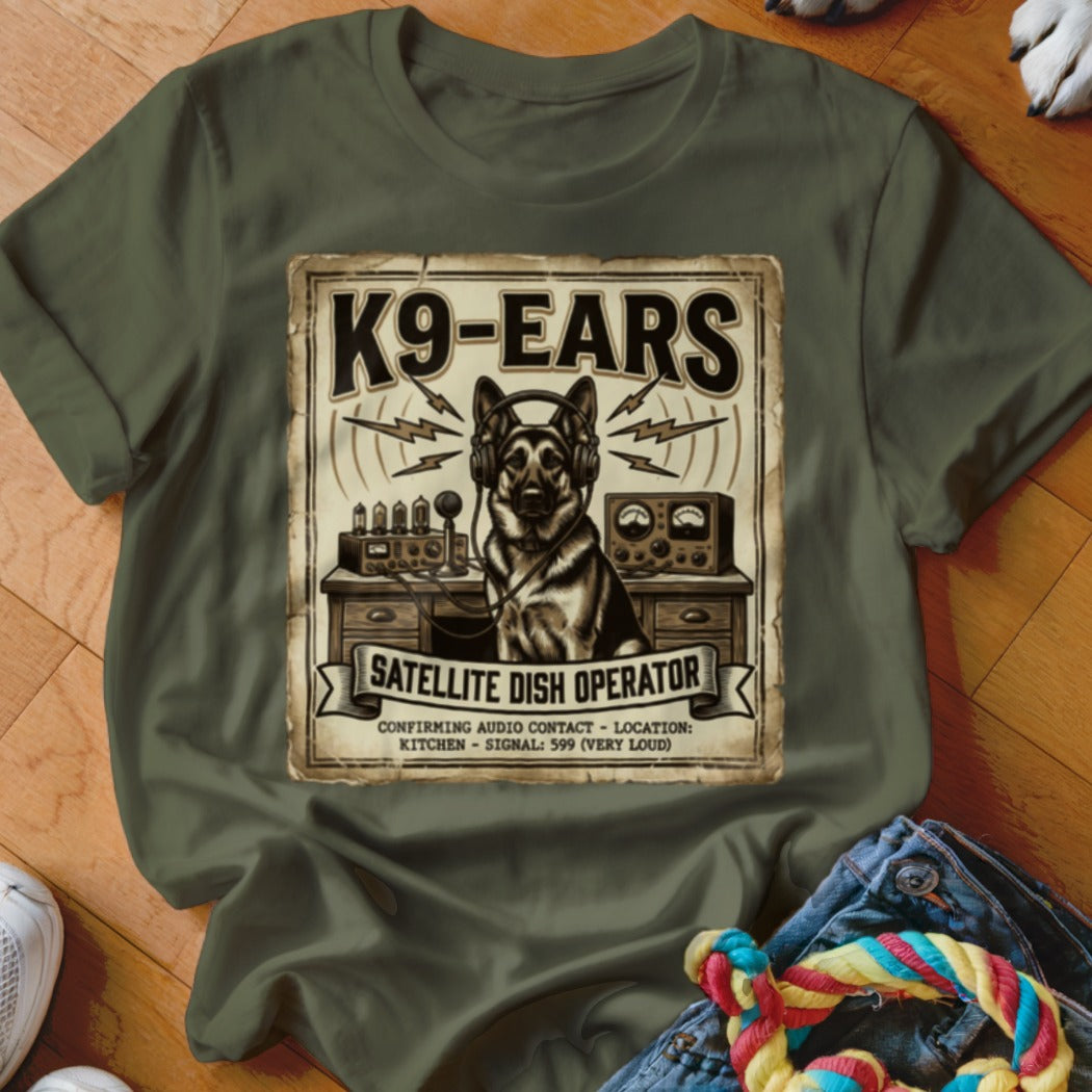 German Shepherd wearing headphones sits at a desk with radio equipment, text reads "K9-EARS Satellite Dish Operator".
