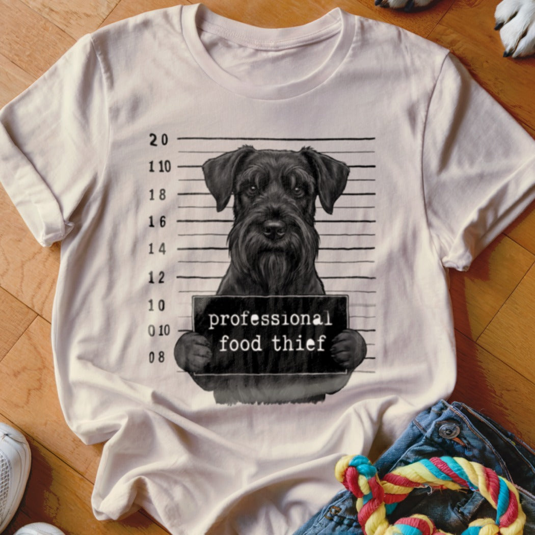 T-shirt graphic of a Schnauzer in a mugshot holding a "professional food thief" sign.
