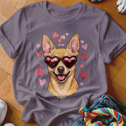 A grey t-shirt featuring a graphic of a smiling Chihuahua wearing heart-shaped sunglasses, surrounded by pink hearts.