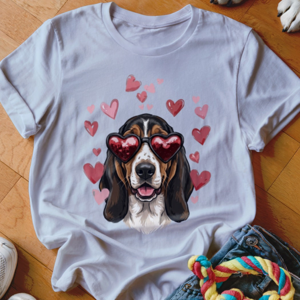 White t-shirt featuring a basset hound wearing heart sunglasses surrounded by pink floating hearts.