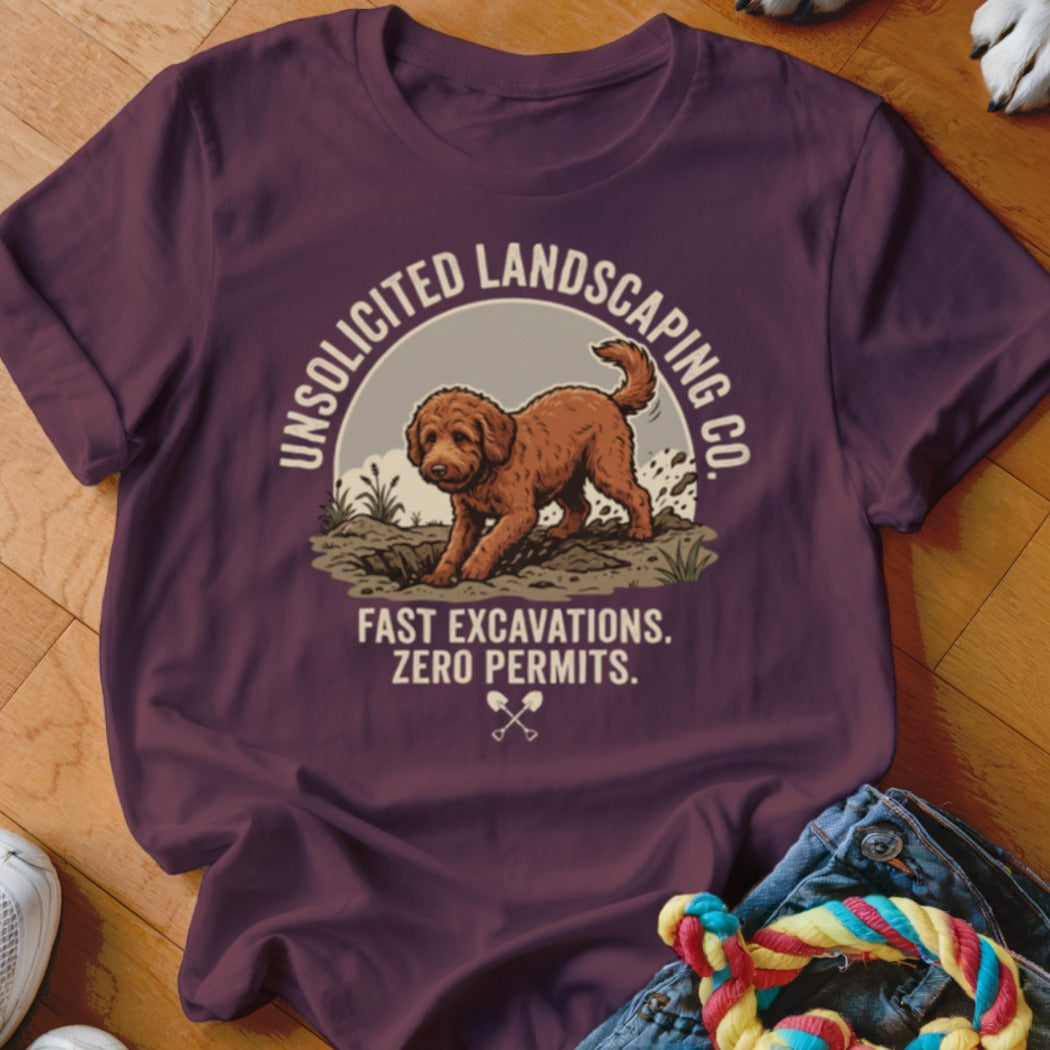 T-shirt with a dog digging dirt with text "Unsolicited Landscaping Co. Fast Excavations. Zero Permits."