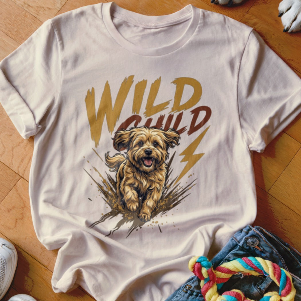 Light beige t-shirt featuring a graphic of a running dog, mud splatters, and the text Wild Child.